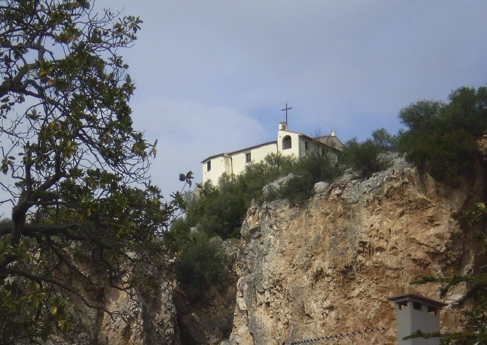 La chiesa di Santa Maria in Castello sulla sommità di uno sperone roccioso sopra Vecchiano, tra alberi e macchia